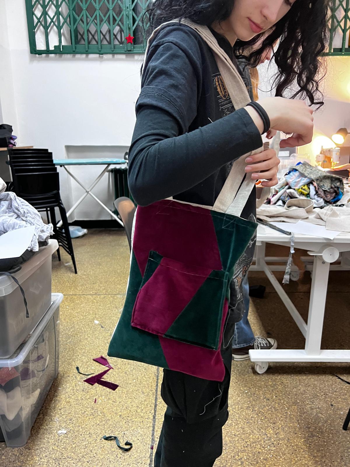 Dziewczyna w akademiku przegląda i segreguje ubrania rozłożone na stole i podłodze.