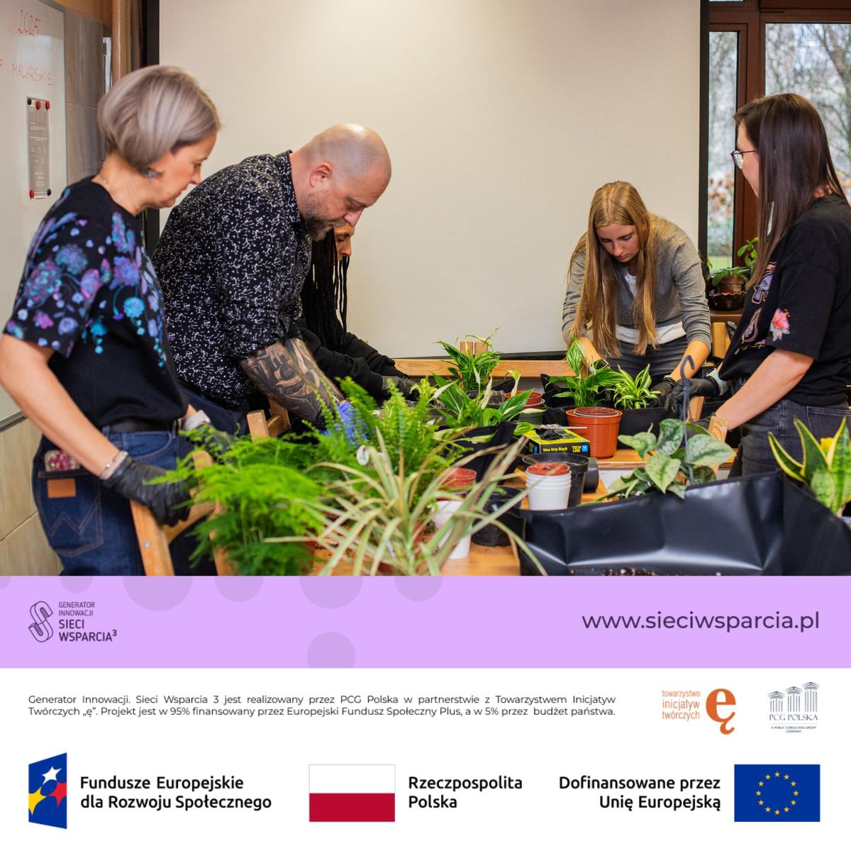 Cztery osoby pracują przy stole z roślinami doniczkowymi podczas warsztatów edukacyjnych.